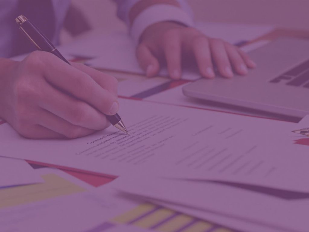 Persoană scriind un document legal cu un pix.